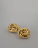 Par de aros tipo stud dorados con diseño en espiral y textura martillada.