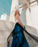 Vestido largo de fiesta con escote en V, parte superior blanca bordada con pétalos y falda plisada azul.