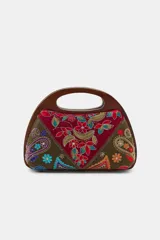 Bolso tipo caja con asa de mano rígida de madera, confeccionado con paneles de tela bordados con motivos florales, paisley y detalles en hilo metalizado.