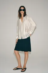 Camisa fluida Zara Woman Collection confeccionada en hilatura con mezcla de lyocell, en color amarillo claro. Presenta escote en pico, manga larga con puño ancho y cierre frontal oculto.