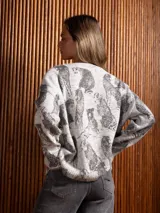 Buzo de punto gris con estampado de tigres en color negro, cuello redondo y mangas largas con puños acanalados.
