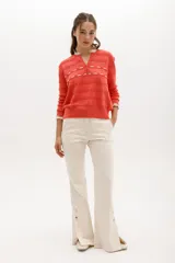 Sweater de punto negro con detalle de calados y lazo en el escote. Tiene ribetes con volados en contraste en el cuello y puños.