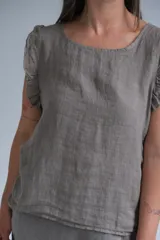 Musculosa color visón con volados en los hombros y botones de nácar en la espalda.