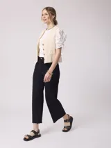 Pantalón de jean negro, tiro alto y pierna ancha con terminación desflecada.