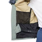 Campera técnica Rip Curl de la línea Anti-Series, color verde grisáceo. Presenta diseño con capucha, cierre frontal completo, múltiples bolsillos frontales con solapa y logo de la marca estampado en el pecho. Ideal para actividades de nieve gracias a su membrana impermeable y transpirable.