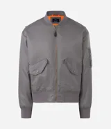 Campera tipo bomber de color verde militar, con cierre frontal, cuello, puños y cintura en tejido rib. Presenta bolsillos frontales con solapa y botón a presión, además de un bolsillo utilitario en la manga.