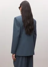 Blazer de corte sastrero en color azul petróleo, con diseño de doble botonadura, solapas clásicas y hombreras estructuradas.