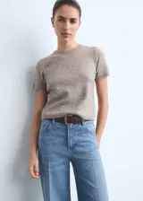 Pantalón jeans de tiro alto y corte wide leg, confeccionado en tejido de algodón con elasticidad. Presenta diseño de cinco bolsillos, cierre frontal con botón y cremallera, y trabillas para cinturón.
