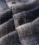 Camisa de franela a cuadros azul marino y beige, de corte comfort, con cuello inglés, abotonadura frontal, manga larga y bolsillo en el pecho.