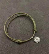 Set de tres pulseras ajustables de cordón con detalles religiosos. Incluye una pulsera roja con cruces, una pulsera marrón trenzada con cruz y medallas, y una pulsera verde con medalla colgante.