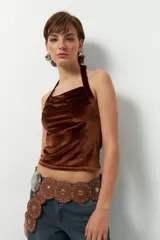 Top negro de terciopelo con escote halter, sin mangas y espalda descubierta.