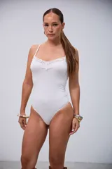 Body blanco elastizado con detalles de encaje en el escote y tirantes finos.