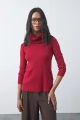 Polera de cuello alto holgado, manga larga y diseño de tejido fino con aberturas laterales en el ruedo.