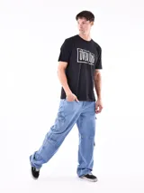 Remera de manga corta color gris topo, corte slim, con cuello redondo y un estampado gráfico en el pecho que combina texto manuscrito con un diseño abstracto en tonos oscuros.