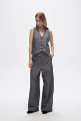 Chaleco gris sin mangas con cuello en V y cierre frontal con botones.