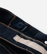 Pantalón de jeans azul oscuro, corte skinny, tiro alto, con bolsillos delanteros y traseros.