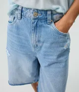 Bermuda jorts de jean en color celeste, con cintura media, calce amplio, bolsillos delanteros y traseros, y detalles de desgastes localizados.