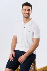Remera polo de piqué manga corta, color blanco con estampado geométrico sutil. Presenta cuello camisero y cartera con dos botones oscuros.
