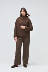 Chaqueta de lana hervida color marrón, con cuello tejido tipo polo, mangas largas y bolsillos frontales aplicados. Presenta un diseño estructurado y minimalista.