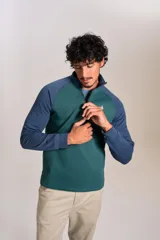 Buzo de cuello alto con cierre frontal parcial, diseño bicolor con cuerpo en verde y mangas raglán en azul. Presenta el logo de la marca bordado en el pecho.