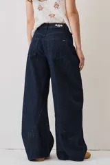 Jeans de denim azul oscuro con corte barrel y diseño amplio en las piernas.