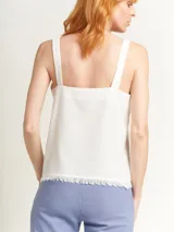 Musculosa verde agua con escote en V, breteles anchos con detalle de argollas de madera y ruedo con flecos.