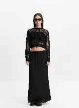 Falda larga color crema, de corte recto y cintura elastizada con lazo ajustable.