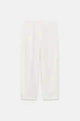 Pantalón de tiro medio confeccionado en una mezcla de lino y algodón. Presenta un diseño de corte recto con trabillas en la cintura, bolsillos laterales y cierre frontal con cremallera, botón y ganchos metálicos.