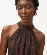 Blusa sin mangas con estampado animal print en tonos marrones y negros, escote halter con cuello alto y cierre posterior con botón. Confeccionada en crepé de viscosa certificada.