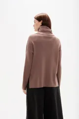 Polera de punto color camel, con cuello alto holgado y mangas largas de diseño amplio.