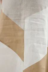 Falda larga de lino con diseño de cortes diagonales en bloques de color blanco, beige y tostado, de corte evasé y caída fluida.