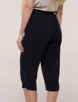 Pantalón capri negro de calce relajado y pierna recta, confeccionado en algodón. Posee cintura elastizada con cordón ajustable, bolsillos delanteros y detalle de presilla con botón en los ruedos.