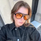 Lentes de sol de aviador con montura negra y lentes naranjas. Fabricados con materiales bio-based G850 y patillas de propionato de celulosa. Cuentan con protección UV400 y lentes TAC polarizadas con recubrimiento antiscratch y superhydrophobic.