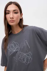 Remera de algodón lavado con textura suave, de calce clásico y manga corta. Presenta un bordado lineal de flores a tono en la parte frontal.