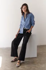 Camisa de jean celeste de manga larga con botones frontales y en los puños.