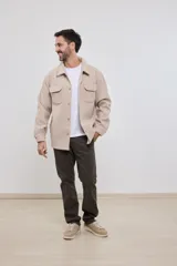 Sobrecamisa de tejido grueso sin forro, con diseño de corte holgado y silueta cuadrada. Presenta cuello clásico, cierre frontal con botones mate y dos bolsillos en el pecho con solapa.