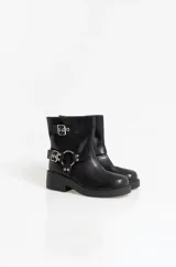 Botas de caña baja en cuero sintético color marrón, con diseño de estilo biker que incluye dos correas horizontales con hebillas metálicas y una argolla decorativa en el lateral. Posee suela y taco bajo de color negro.