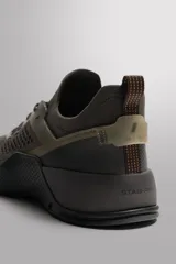 Zapatilla deportiva de entrenamiento con parte superior de tejido de punto transpirable en color verde militar. Cuenta con refuerzos Shield Protect Max en puntera y talón, cierre mediante cordones, tirador posterior y entresuela con tecnología Stabi-pro para mayor estabilidad.