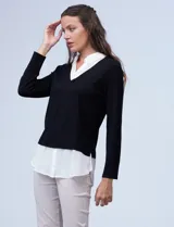 Buzo combinado con torso de tejido de punto fino en color negro y detalles de cuello y ruedo en gasa blanca que simulan una camisa debajo. Presenta escote en V y mangas largas.