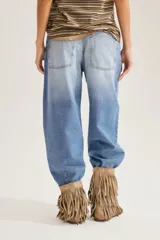 Jean slouchy de tiro alto en color celeste con lavado claro, corte amplio tipo barrel y diseño de perneras curvadas que se estrechan en los tobillos.