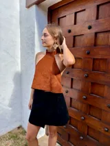 Caravanas colgantes de diseño floral con pétalos texturizados en tono dorado y detalles de pequeñas perlas en la parte superior.