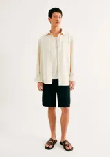 Short de playa color negro, de corte recto y largo hasta la rodilla, con cintura elástica.