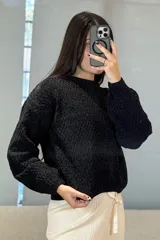 Buzo de tejido chenille con textura en relieve, cuello redondo y mangas largas con puños ajustados.