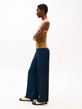 Pantalón largo de viscosa color azul marino, de corte holgado y cintura elástica. Presenta logo metálico de Tommy Hilfiger en la cadera.