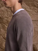 Sweater de punto en color azul marino, con cuello redondo y mangas raglán. Presenta un tejido acanalado fino y puños elásticos.