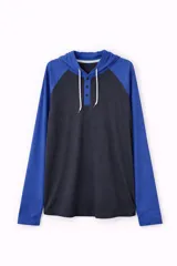 Remera de manga larga con capucha, estilo raglán, con cuerpo en gris oscuro y mangas y capucha en azul. Presenta una abertura frontal con botones y cordones ajustables en la capucha.