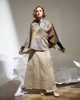 Poncho de lana merino afieltrada multicolor con diseño geométrico. Se puede usar de forma desestructurada, suelta o cruzada, suelta o atada, se adapta a diferentes cuerpos y marcando diversas siluetas.
