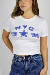 Remera corta de algodón blanca con estampado azul en el pecho que dice "NYC 19 90" junto con una estrella.