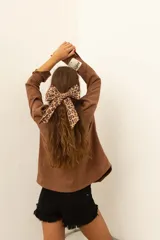Camisa marrón de corte recto con botones y bolsillos frontales.