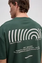 Remera oversize de manga corta color marrón con estampa pequeña en el pecho y estampa geométrica en la espalda.